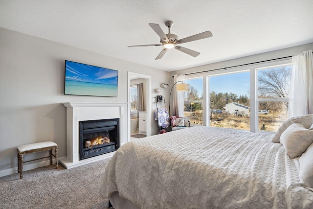 bedroom featuring carpet flooring, ensuite bath, ceiling fan, and a textured ceiling