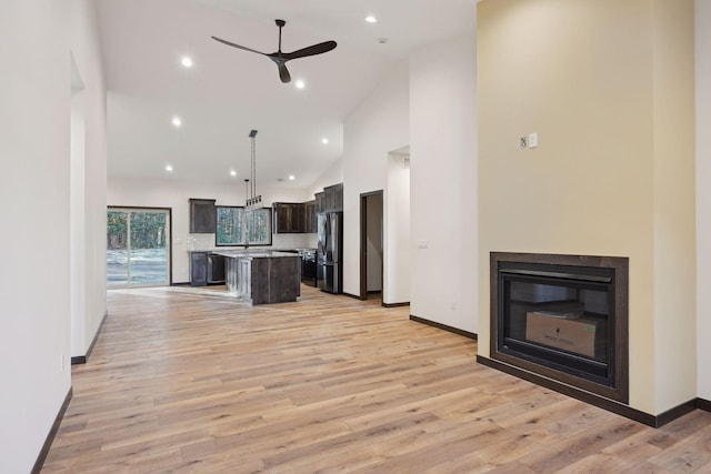 kitchen with stainless steel refrigerator, ceiling fan, backsplash, pendant lighting, and a kitchen island