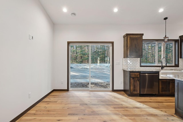 kitchen with dishwasher, tasteful backsplash, light stone counters, pendant lighting, and dark brown cabinets