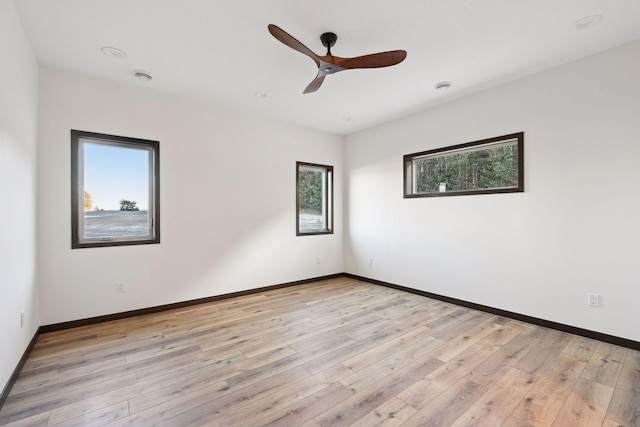 empty room featuring ceiling fan, a healthy amount of sunlight, and light wood-type flooring