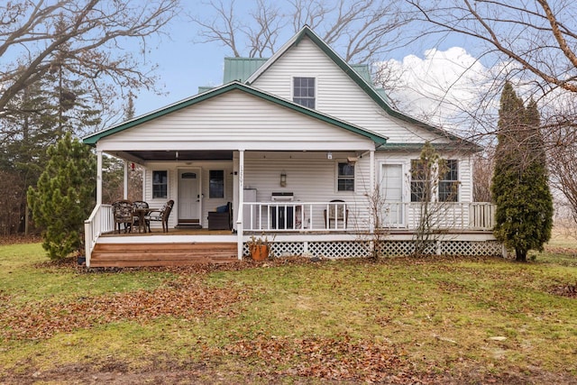 rear view of house featuring a yard and covered porch