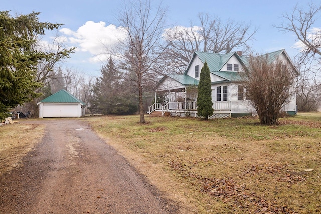 view of side of property featuring covered porch, a garage, and an outdoor structure