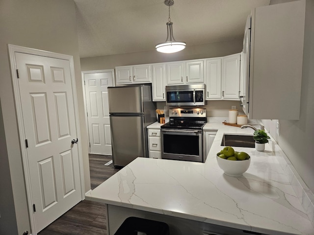 kitchen featuring light stone countertops, appliances with stainless steel finishes, decorative light fixtures, dark hardwood / wood-style floors, and white cabinetry