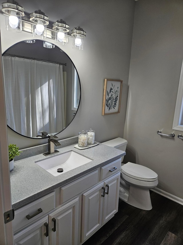 bathroom featuring vanity, hardwood / wood-style flooring, and toilet