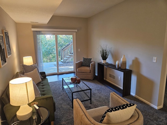 living room featuring dark carpet and a textured ceiling