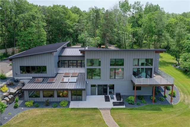 back of property featuring a lawn, a patio area, and an outdoor living space