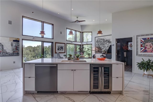 kitchen featuring ceiling fan, sink, pendant lighting, white cabinets, and wine cooler