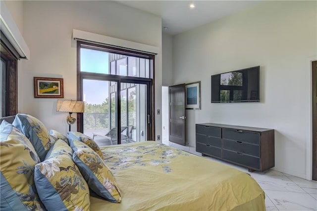 bedroom with access to exterior and a towering ceiling