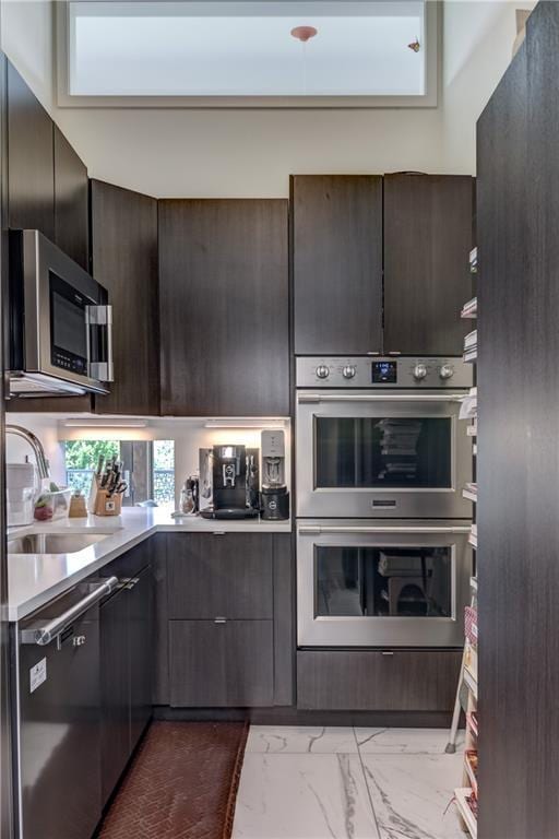 kitchen featuring appliances with stainless steel finishes, dark brown cabinets, and sink