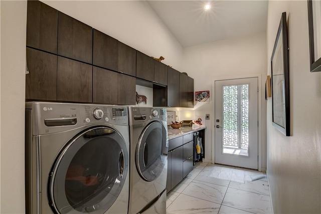 laundry area featuring washing machine and dryer and cabinets