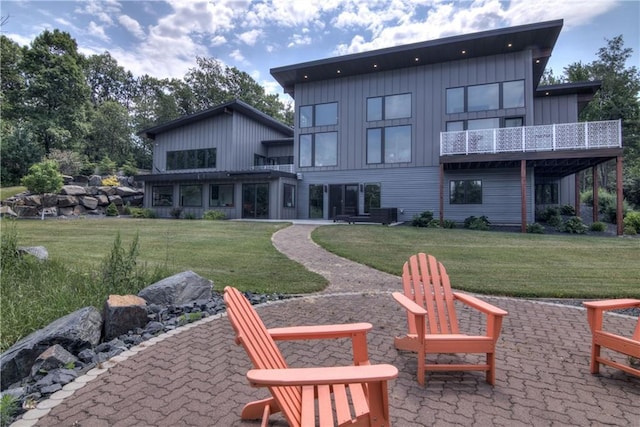 rear view of property with a lawn and a patio area