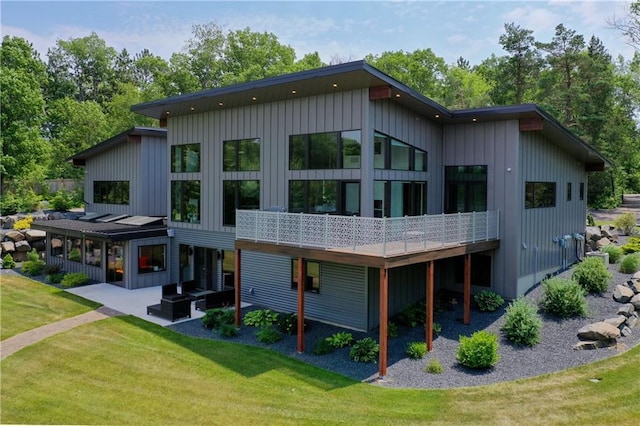 back of house with a patio area and a lawn