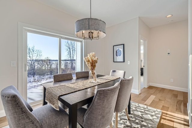 dining room with an inviting chandelier and light hardwood / wood-style flooring