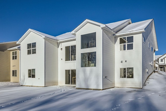 view of snow covered rear of property