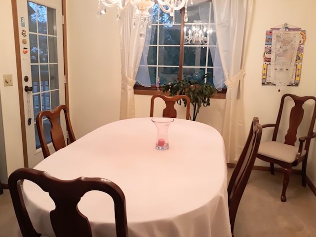 dining area featuring a notable chandelier and carpet flooring