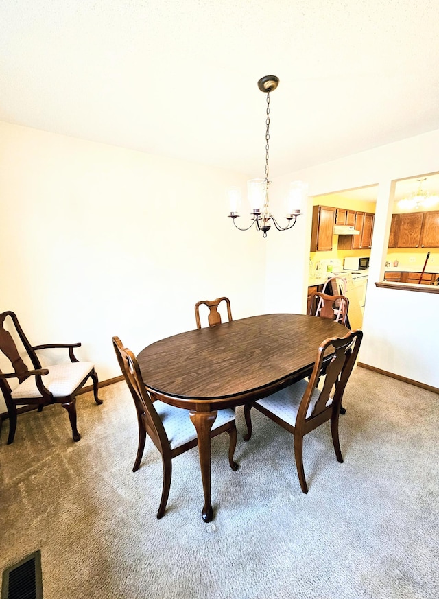 dining space featuring an inviting chandelier and carpet