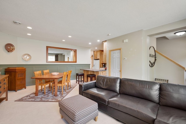 living room with a textured ceiling and light colored carpet