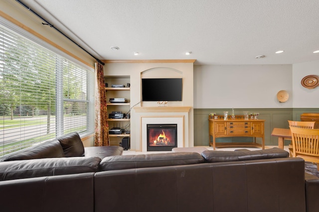 living room with built in shelves and a textured ceiling