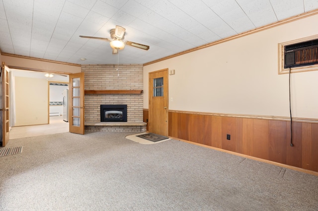 unfurnished living room featuring light carpet, ceiling fan, crown molding, an AC wall unit, and wood walls