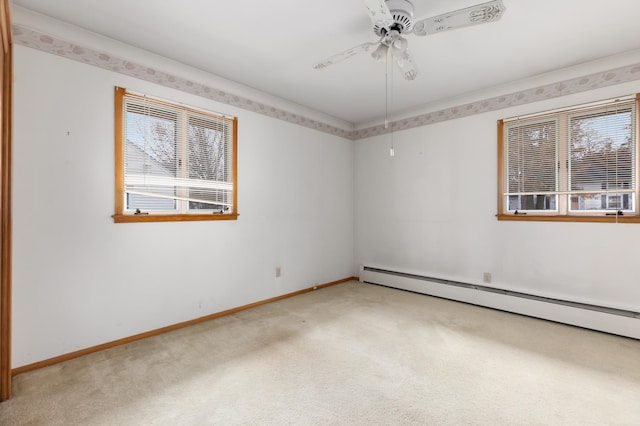 carpeted spare room featuring ceiling fan, a healthy amount of sunlight, and baseboard heating