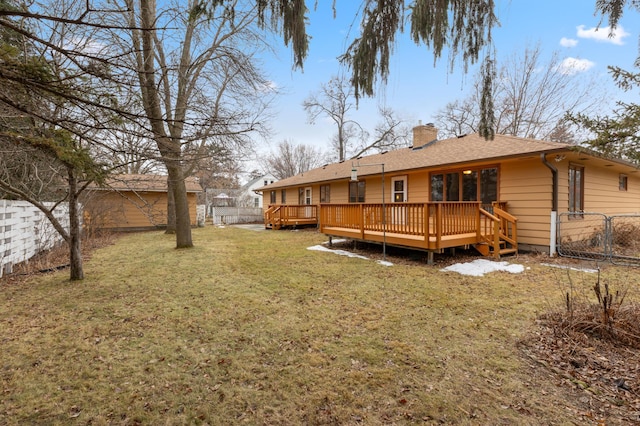 rear view of house with a yard and a wooden deck