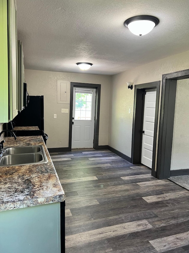 kitchen with a textured ceiling, dark hardwood / wood-style floors, and sink