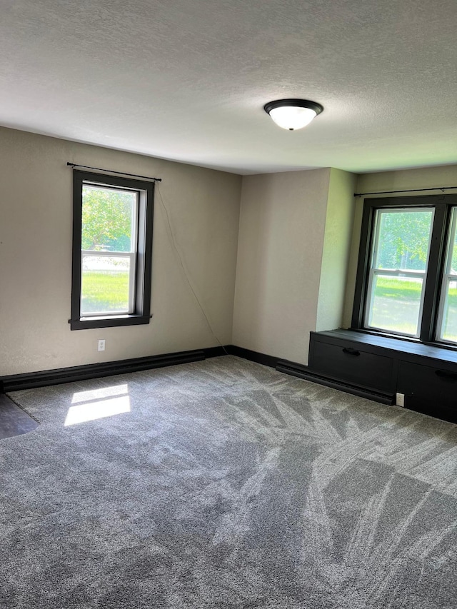 carpeted empty room featuring a textured ceiling