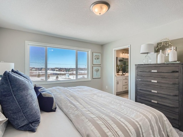 bedroom featuring a textured ceiling and ensuite bath