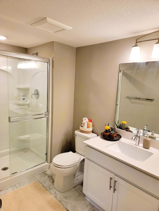 bathroom with a textured ceiling, vanity, toilet, and walk in shower