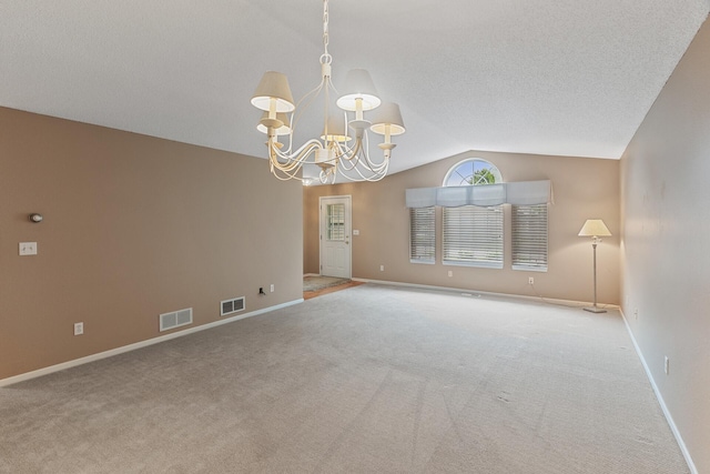 empty room featuring vaulted ceiling, light carpet, a notable chandelier, and a textured ceiling