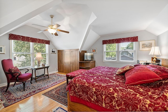 bedroom with multiple windows, wood-type flooring, vaulted ceiling, and ceiling fan