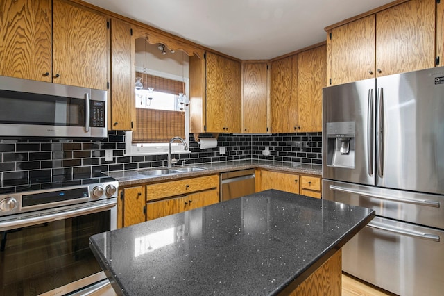 kitchen featuring stainless steel appliances, tasteful backsplash, a kitchen island, and sink