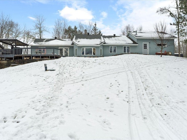 snow covered house featuring a deck