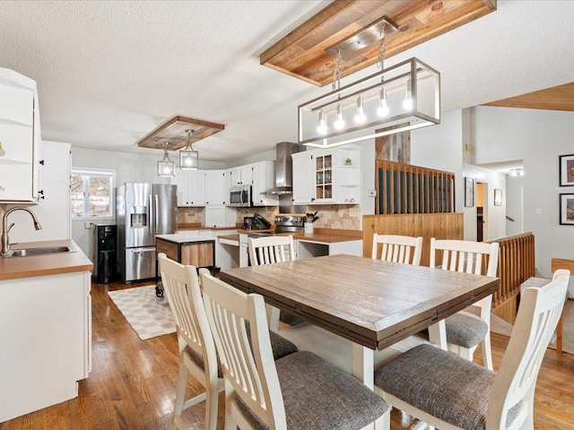 dining space with a textured ceiling, dark hardwood / wood-style floors, and sink