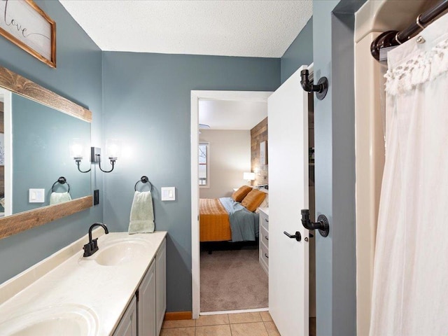 bathroom featuring tile patterned floors, vanity, and a textured ceiling