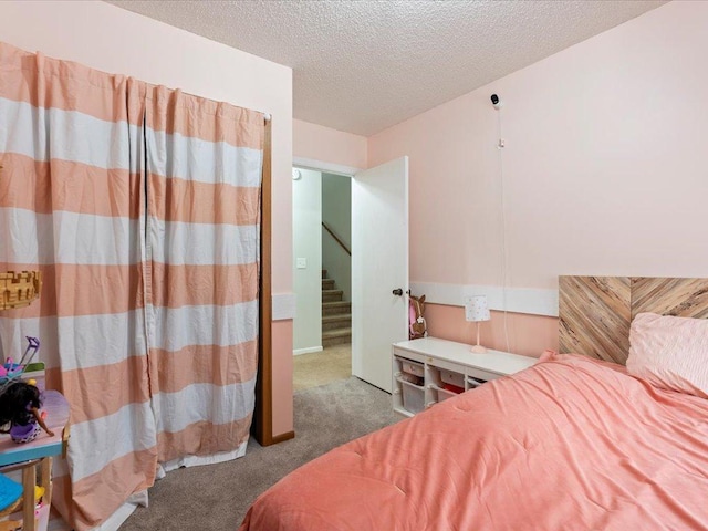 bedroom with carpet and a textured ceiling