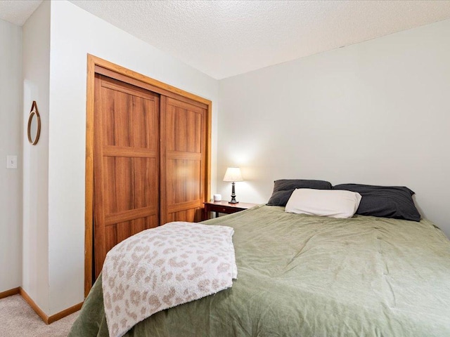 bedroom featuring carpet flooring and a textured ceiling