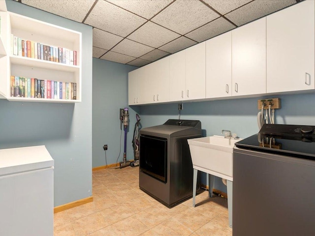 clothes washing area with cabinets and separate washer and dryer