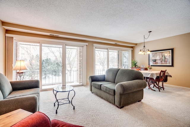 living room with a notable chandelier, carpet floors, and a textured ceiling