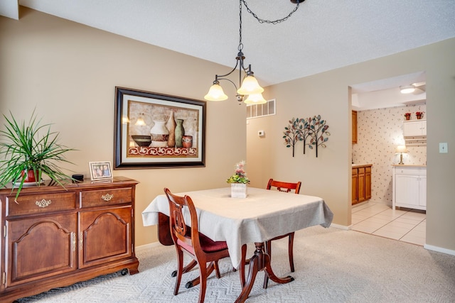 dining area featuring an inviting chandelier and light carpet