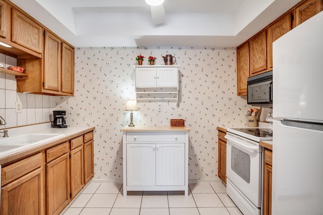 kitchen featuring light tile patterned floors, white appliances, sink, and a raised ceiling