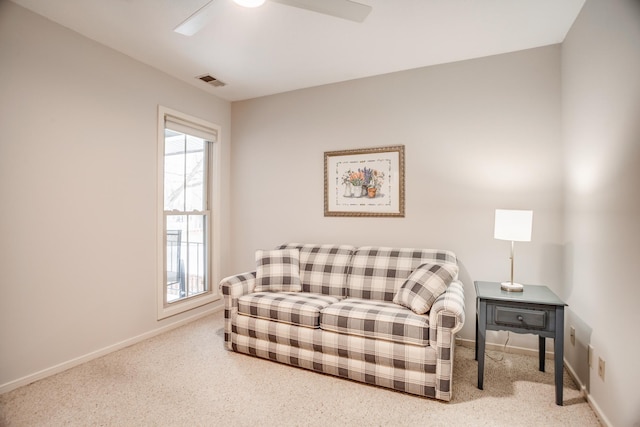 living area featuring ceiling fan, plenty of natural light, and carpet flooring