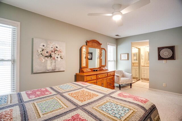 carpeted bedroom with ceiling fan and ensuite bathroom