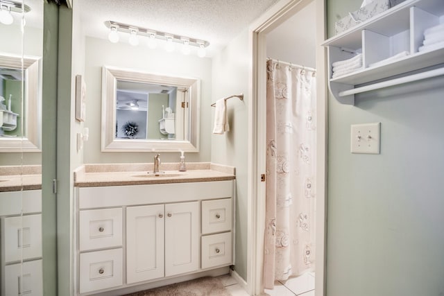 bathroom featuring vanity, rail lighting, a textured ceiling, and walk in shower