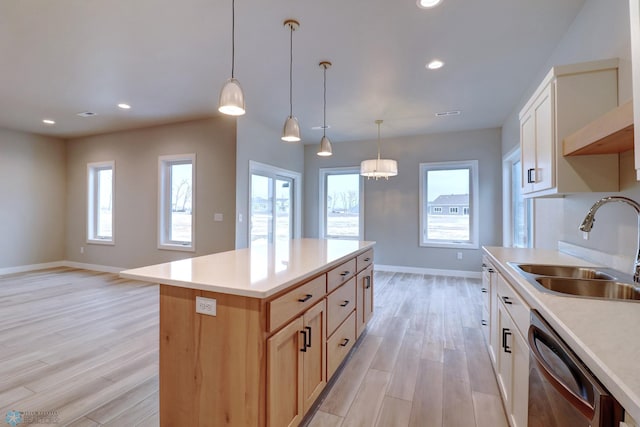 kitchen featuring a wealth of natural light, sink, dishwasher, a center island, and light hardwood / wood-style floors