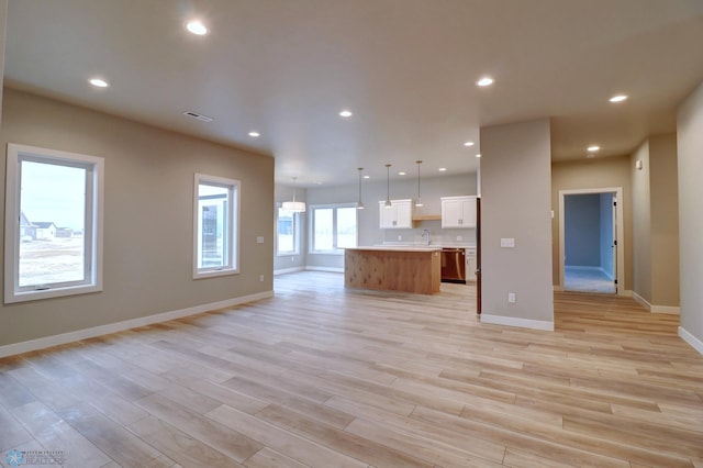 unfurnished living room featuring light hardwood / wood-style floors and sink