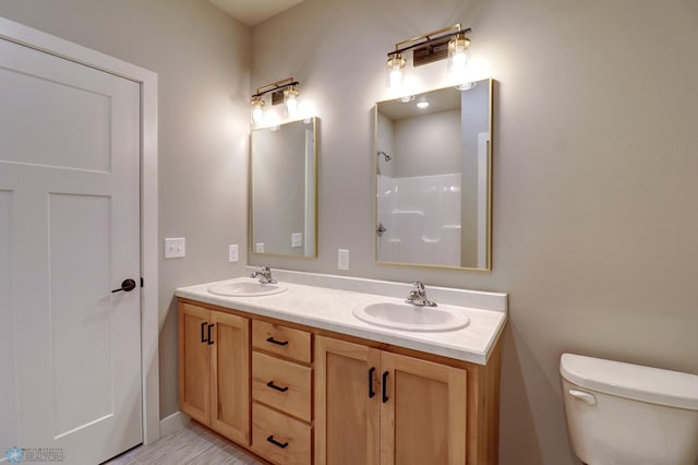 bathroom with vanity, toilet, and walk in shower