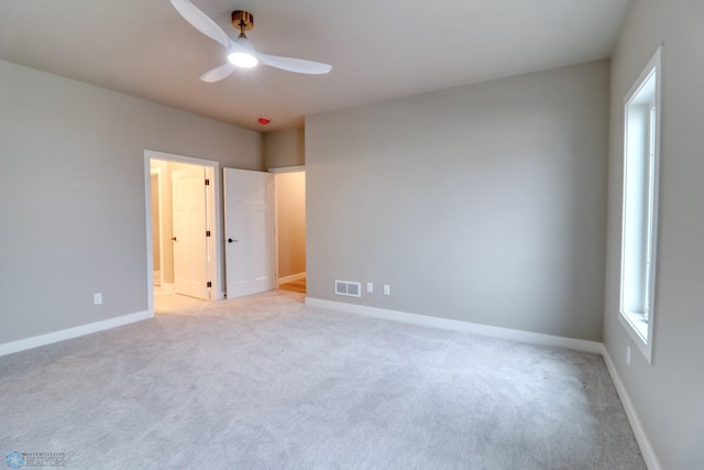 carpeted spare room with ceiling fan