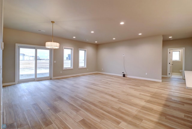 spare room featuring light hardwood / wood-style flooring and a healthy amount of sunlight