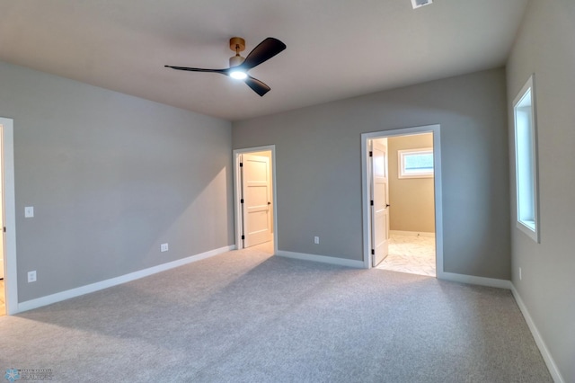 unfurnished bedroom with connected bathroom, ceiling fan, and light colored carpet